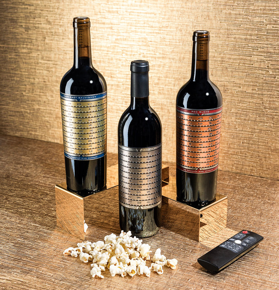 Unshackled red wine trio with cabernet sauvignon, pinot noir, red blend on gold next to popcorn