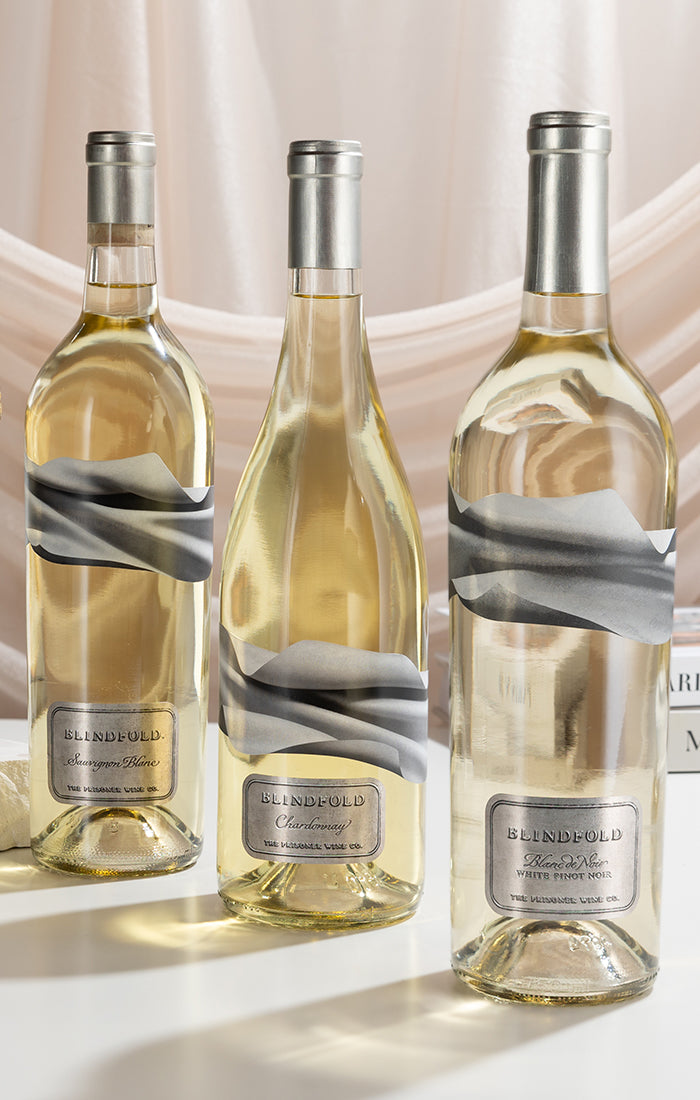 bottles of wine on a table with glasses and books