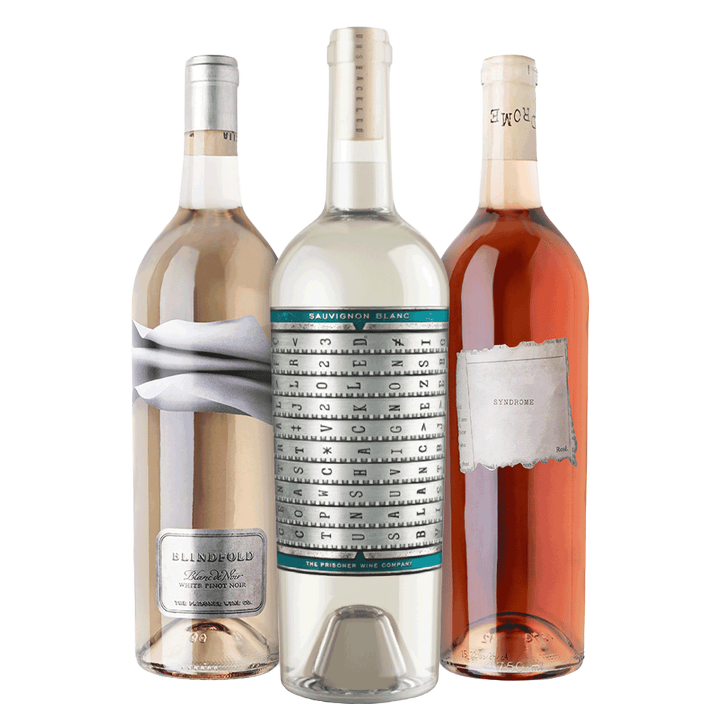 Three wine bottles grouped together against a plain white background: a bottle of Blindfold Blanc de Noirs on the left, a bottle of Unshackled Sauvignon Blanc in the center , and a bottle of The Prisoner Syndrome Rosé on the right.