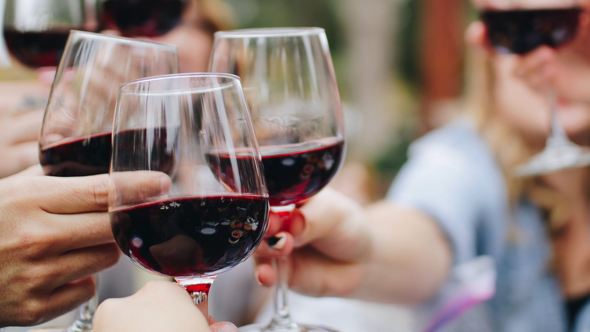 3 people cheers with glasses of red wine