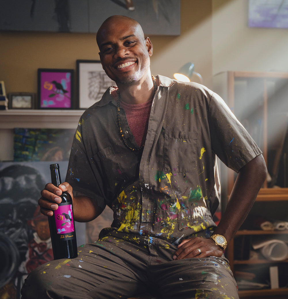 image of artist Omari Booker with a wine bottle in his hand