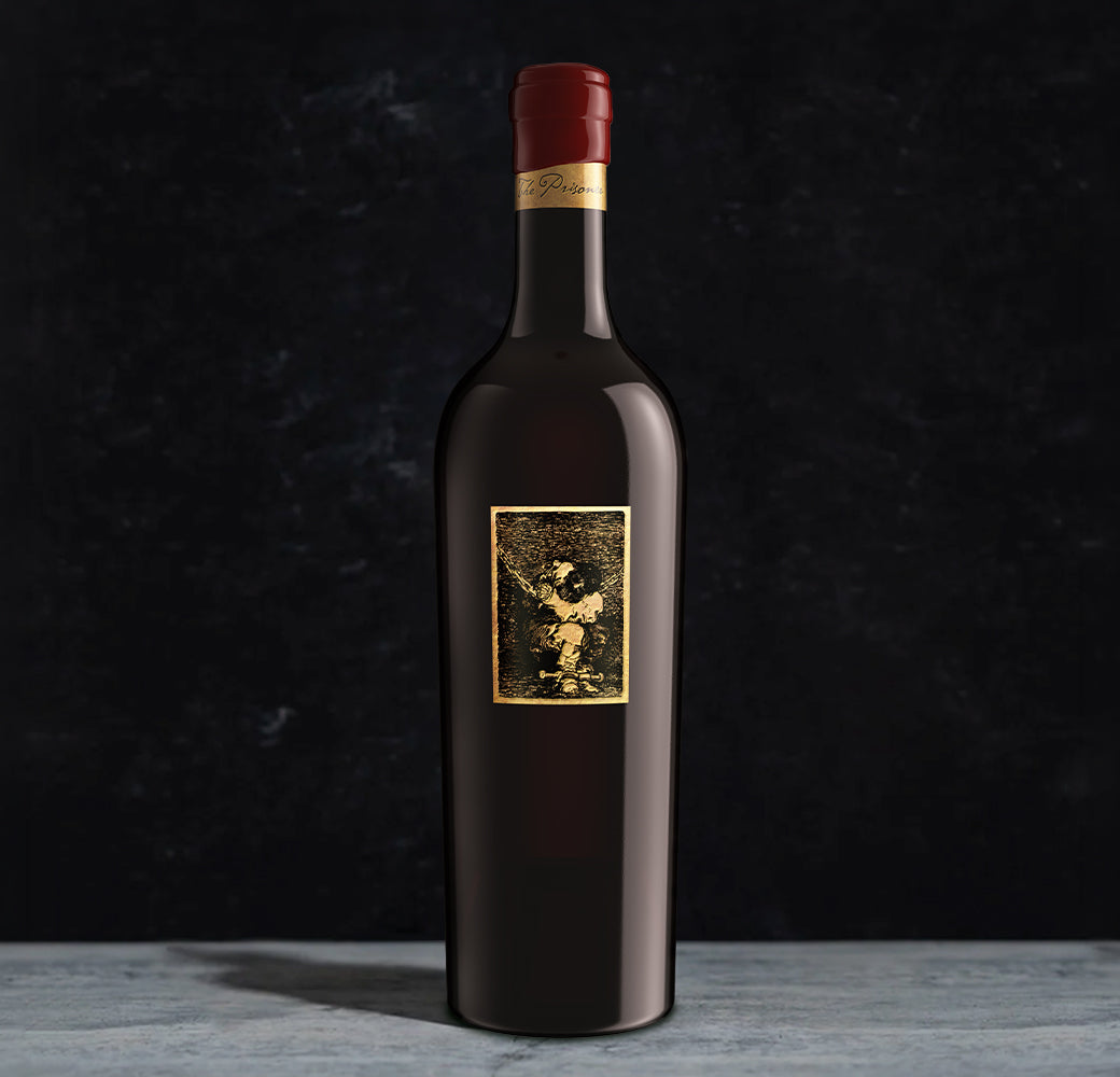 A bottle of The Prisoner Grail Red Wine with a gold label on a dark background