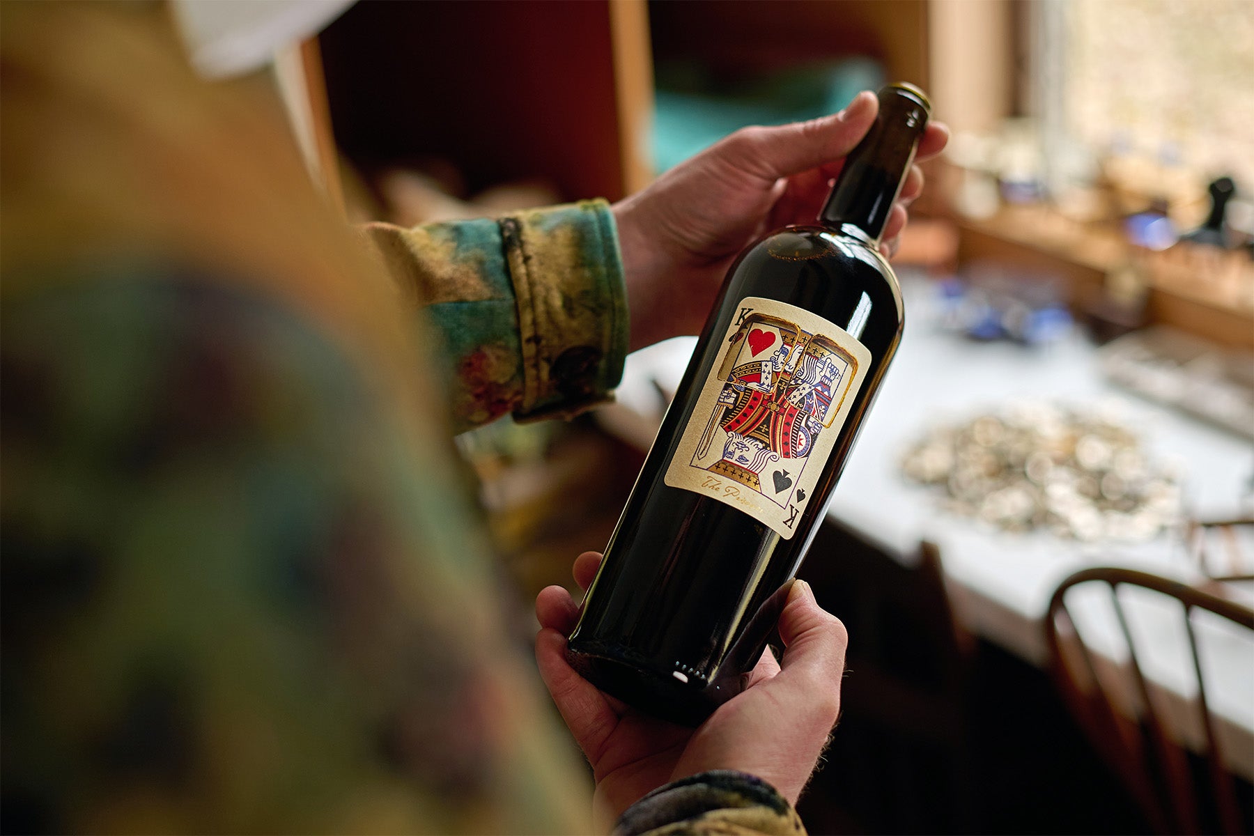 A man holds a bottle of The Prisoner x Corrections wine 