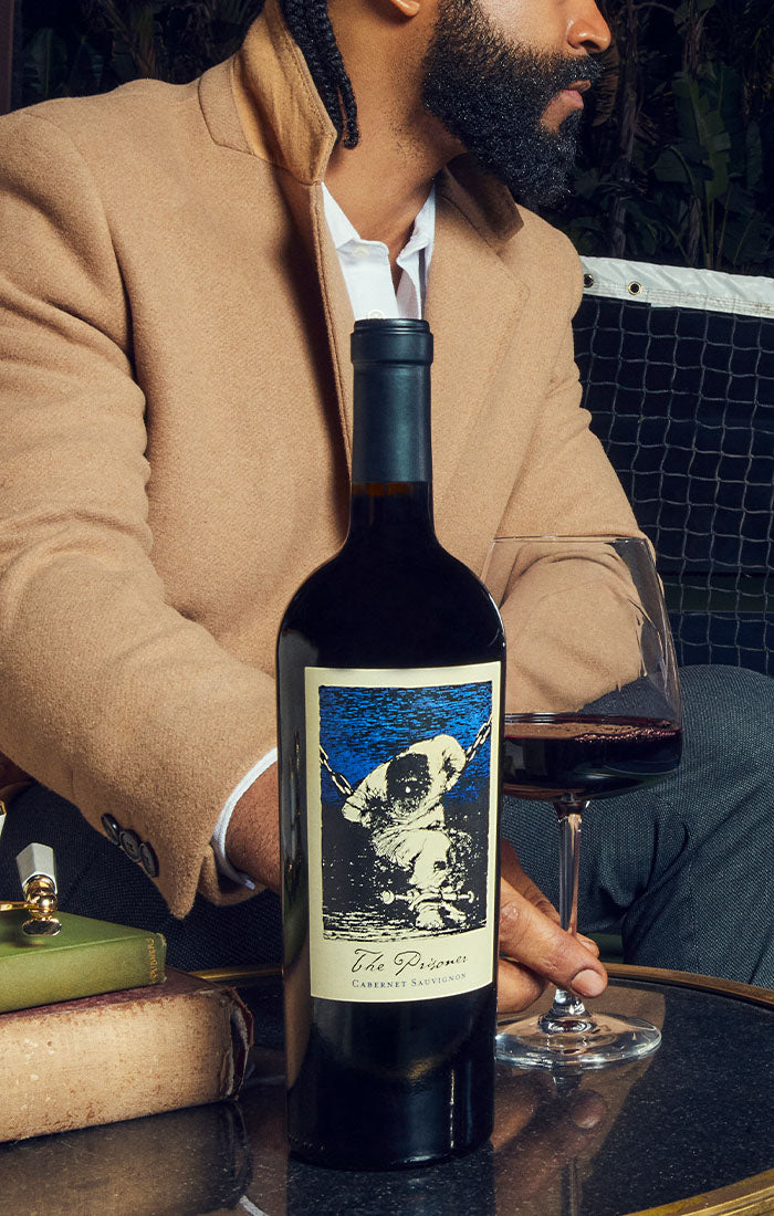 Bottle of The Prisoner Cabernet Sauvignon on a table in a tennis court