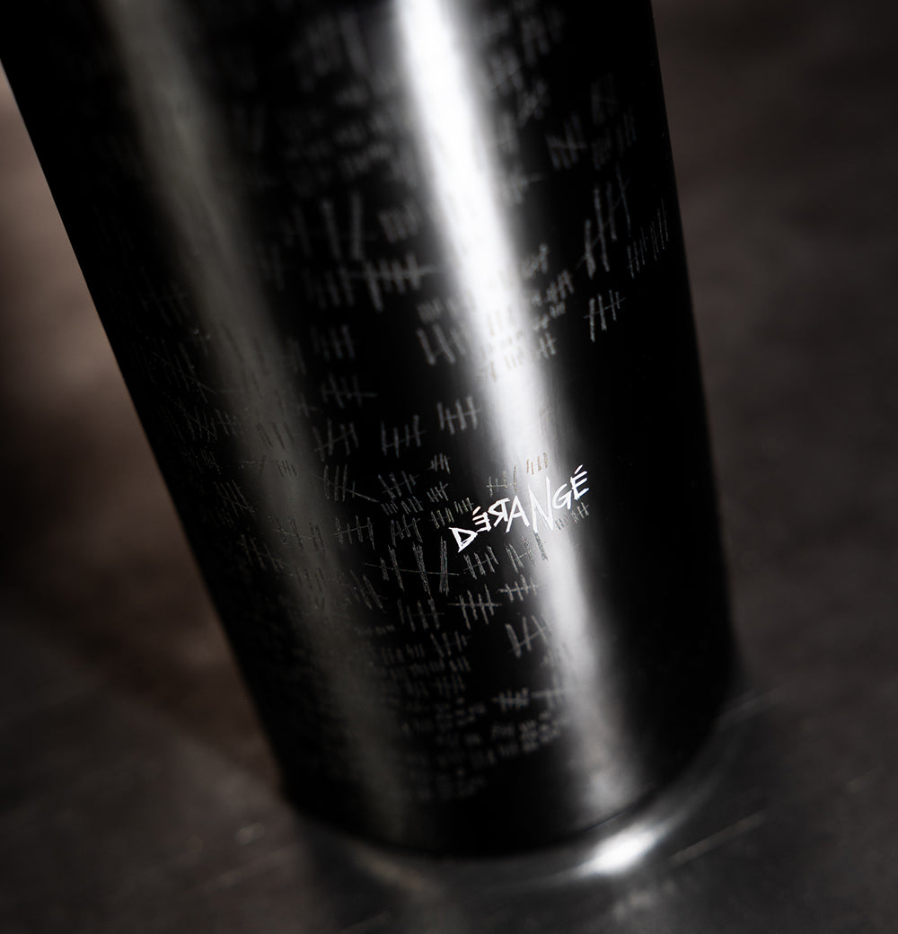 Derange Red Wine bottle on a black and gray background up close