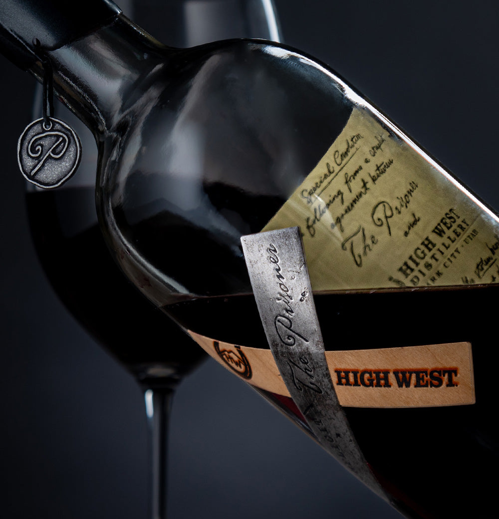 Close up bottle shot of complicit red wine aged in high west whiskey barrels