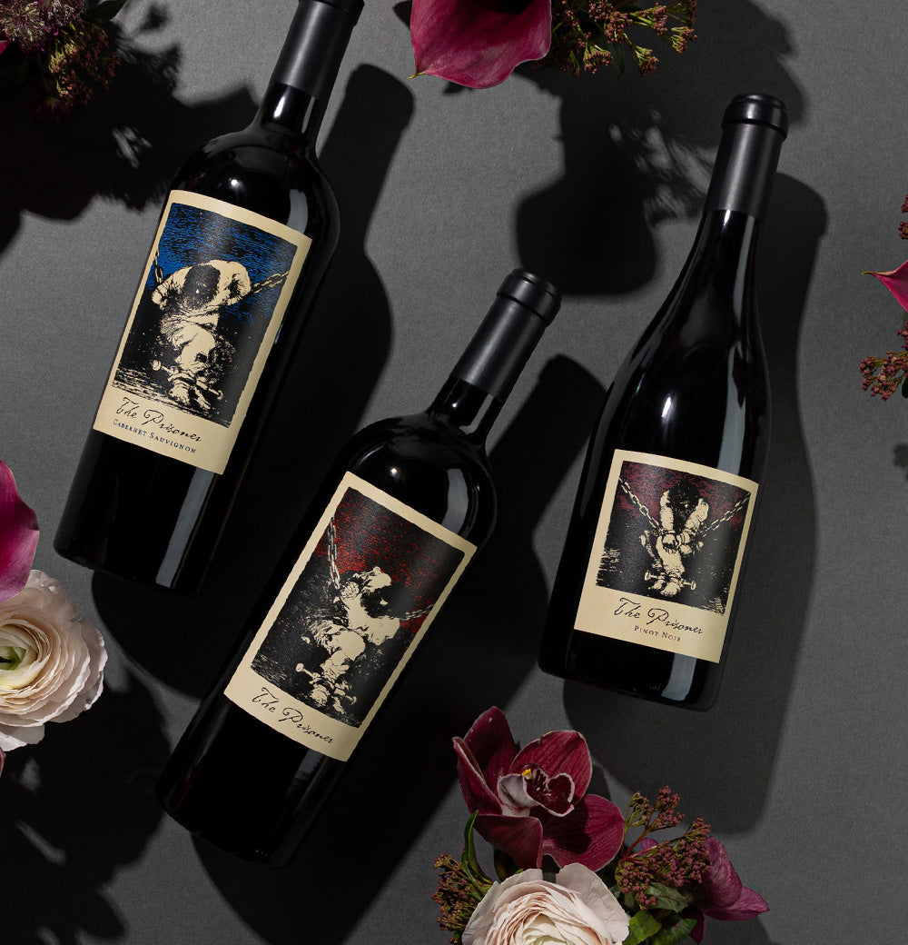 The Prisoner Red Blend, Pinot Noir and Cabernet Sauvignon next to flowers