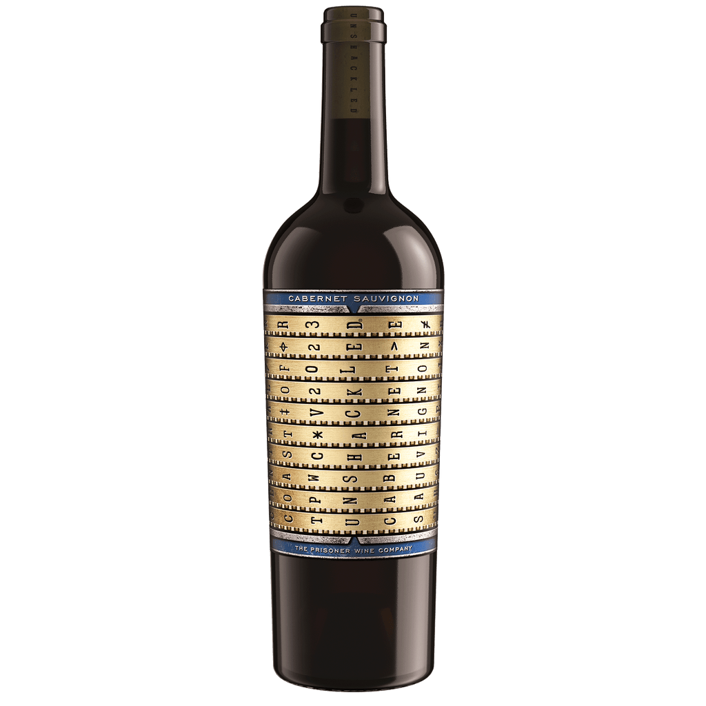 A bottle of Unshackled Cabernet Sauvignon wine with a dark glass body, a black neck foil, and a cream-colored label featuring a gold circular graphic and blue text bands.