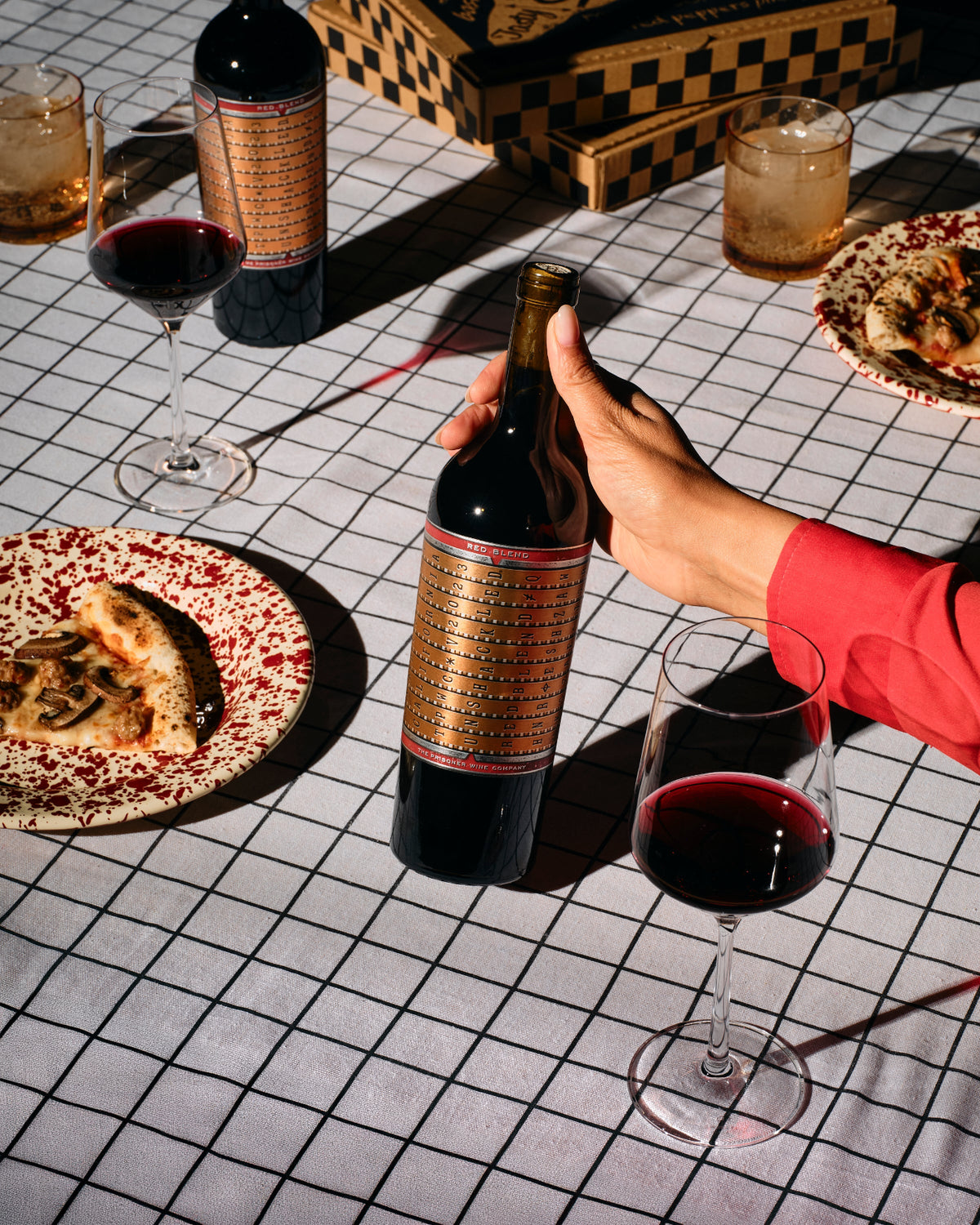 wine bottle with a piece of pizza and 2 wine glasses