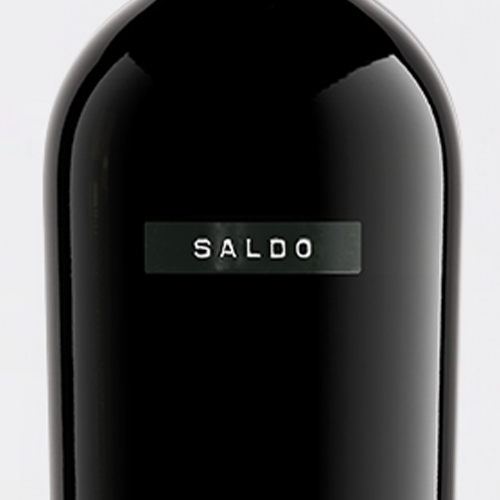 Close-up of a glossy black bottle with a rectangular metallic label reading 'SALDO' in white text, set against a light gray background.